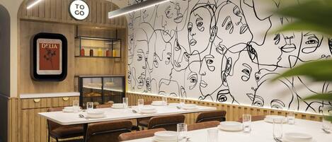 Interior de un restaurante con paredes de paneles de madera, un mural y mesas dispuestas para comer.