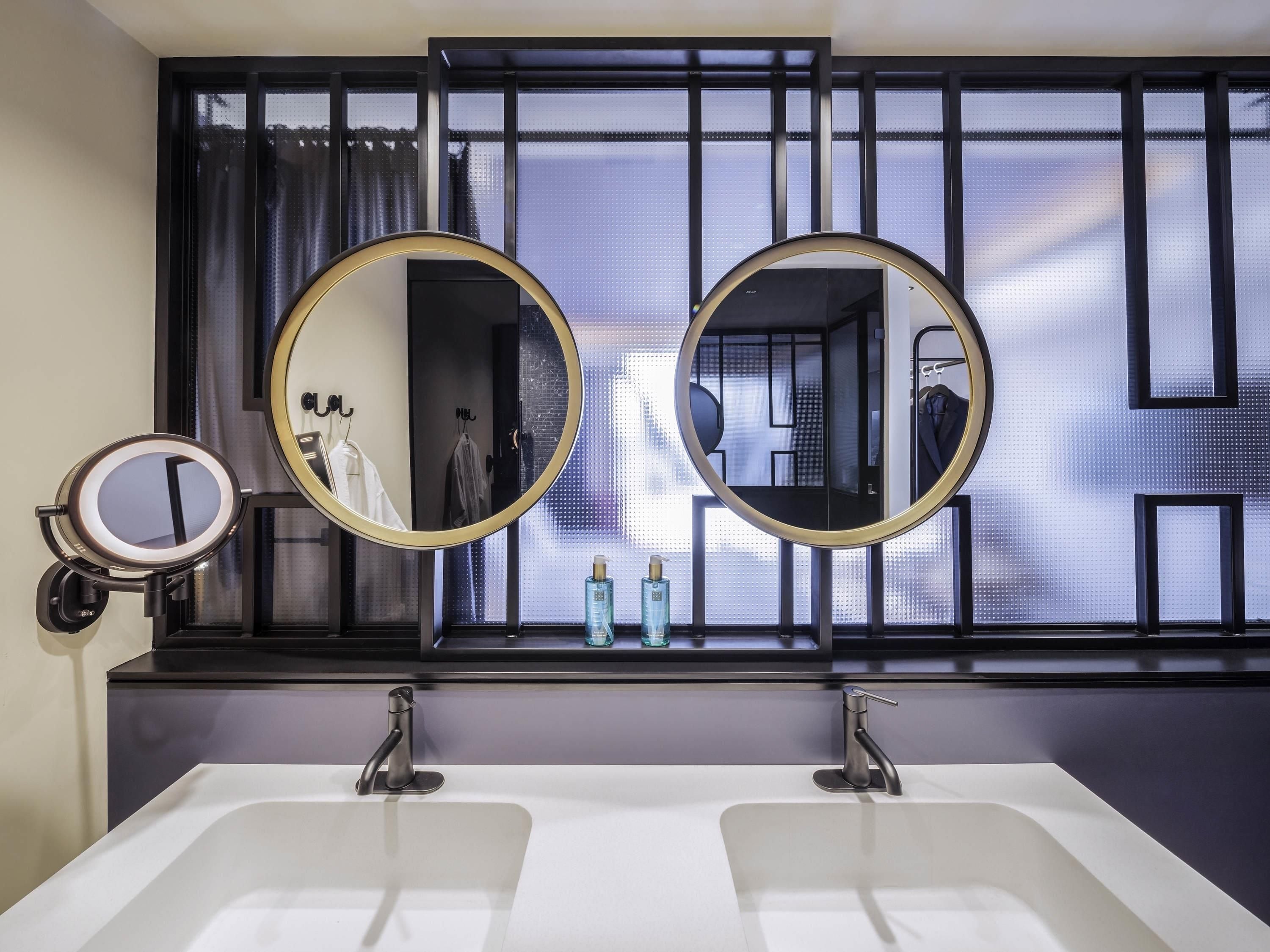 A bathroom with two sinks, a large mirror, and a window with a view.