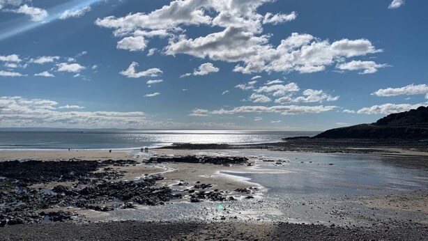 A beach with a clear sky, rocky shoreline, and distant hills. - Spacious, Stylish House - 500 yards to the sea front (West Cross)