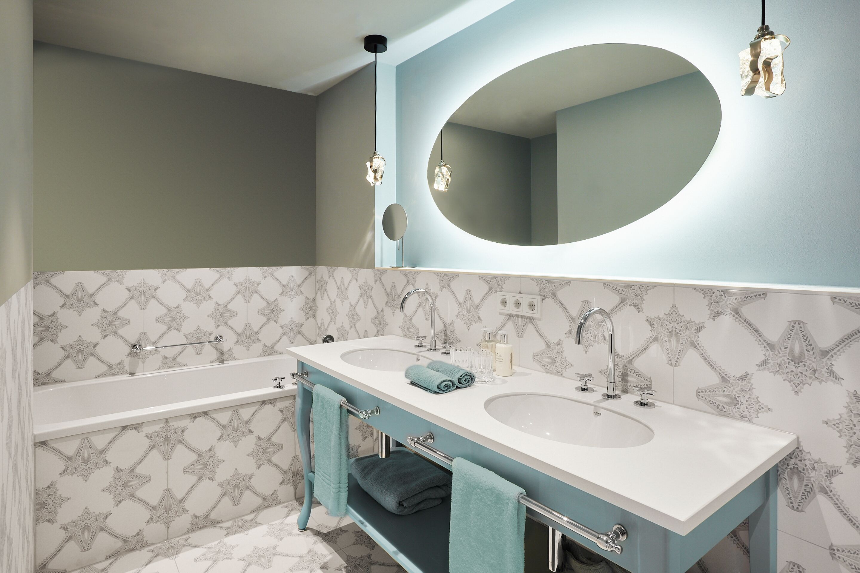 A bathroom with two sinks, a large mirror, and a towel rack.