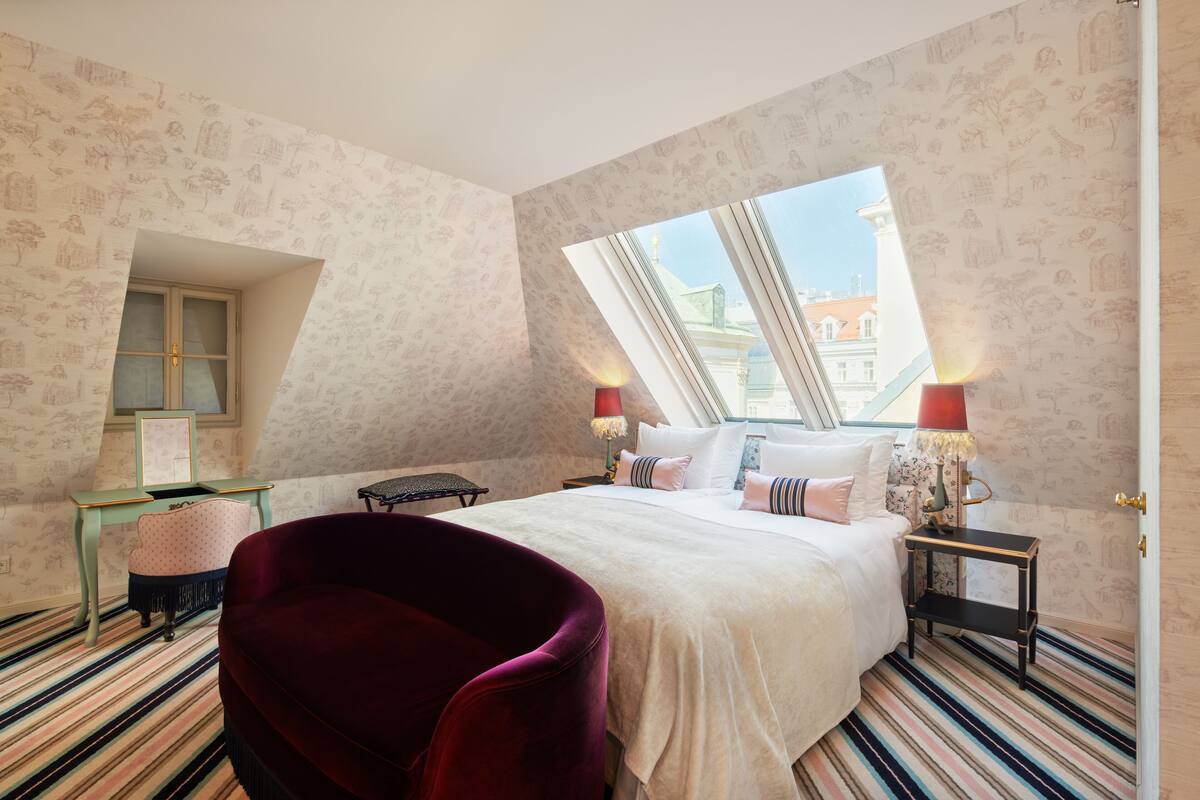 Un dormitorio con una cama grande, una ventana, un escritorio y una silla.