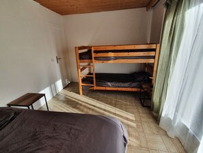 Cozy retreat with a single bed, wooden headboard, and small table for your essentials.