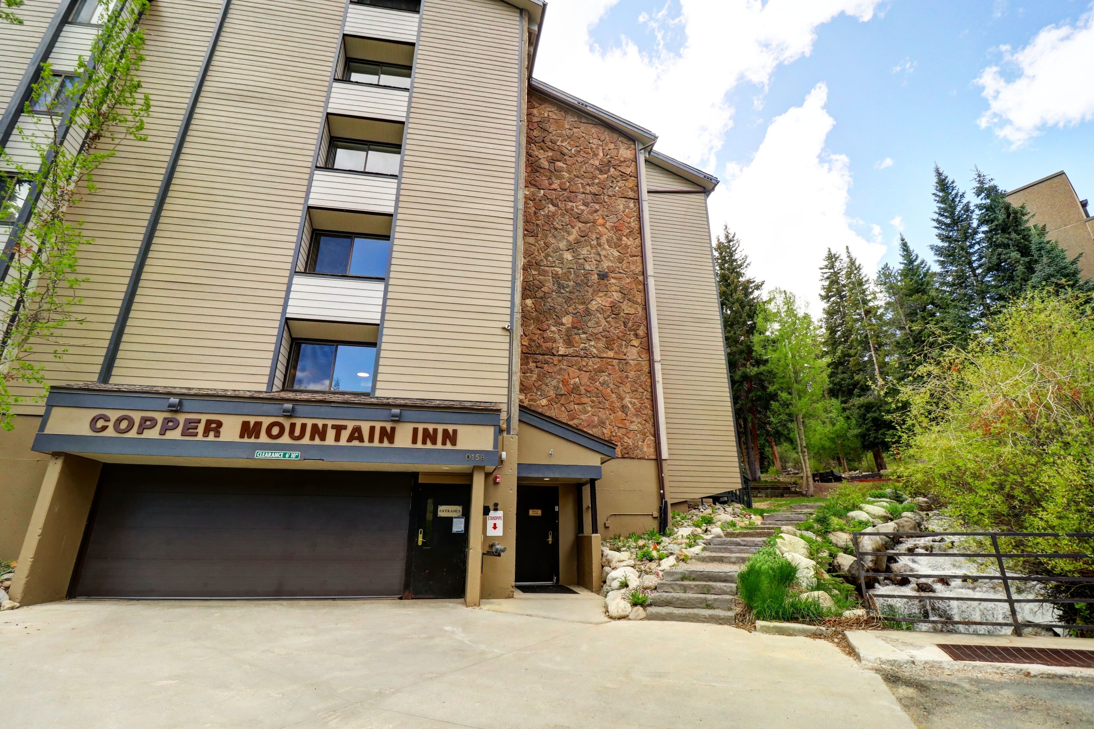 A building with a sign reading "Copper Mountain Inn" and a stone facade.