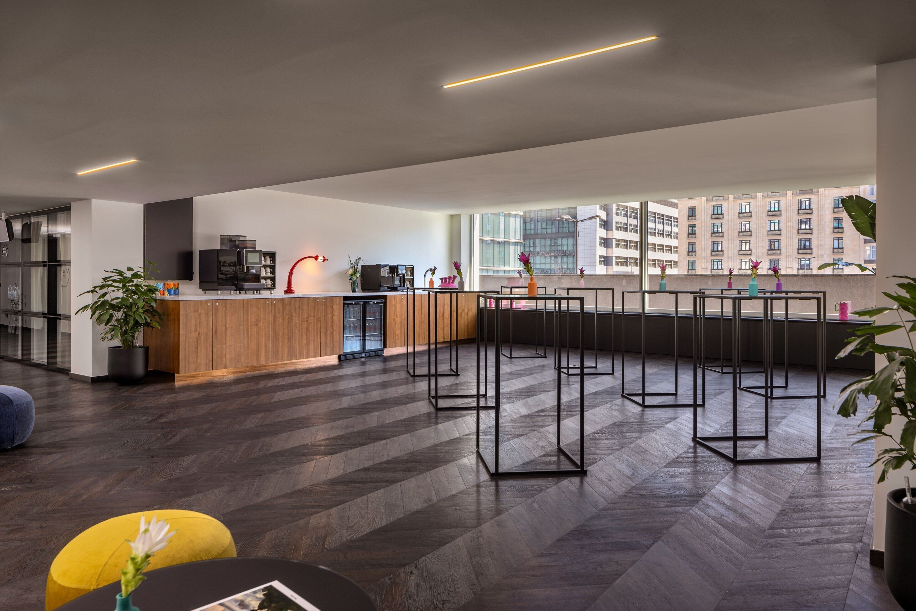 A modern kitchen with a wooden countertop, built-in appliances, and a view of the city through large windows.