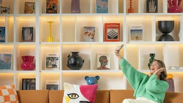 Un salon moderne avec un canapé, une table basse et une bibliothèque remplie de livres et d’objets décoratifs.