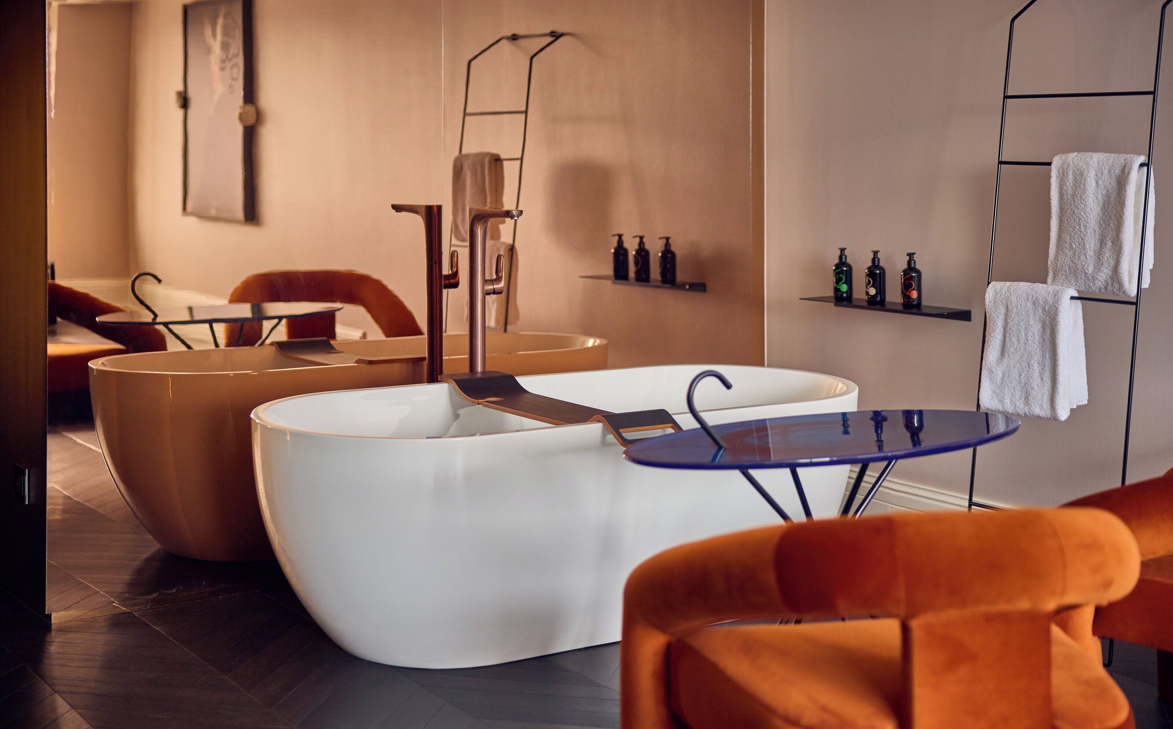 Un moderno spa con una bañera grande, una camilla de masaje y una mesita con botellas.