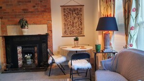 A cozy living room with a fireplace, a round table, and a sofa.