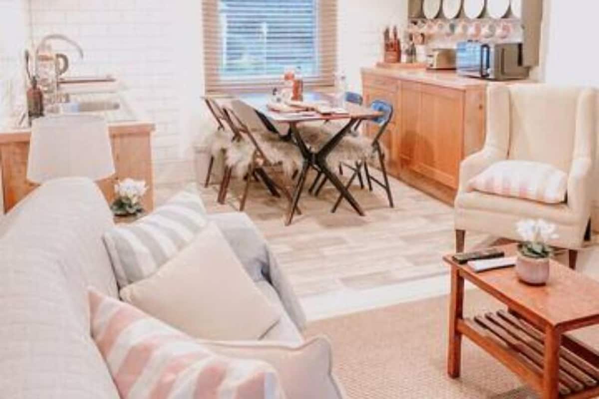 A cozy living room with a sofa, a coffee table, and a dining area with a table and chairs.