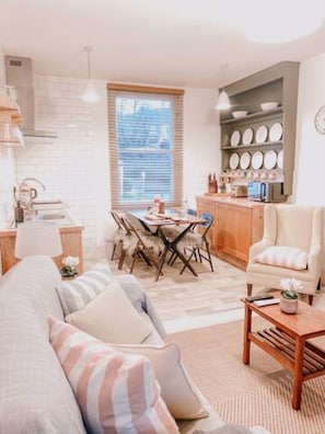 A cozy living room with a sofa, a coffee table, and a dining area with a table and chairs.