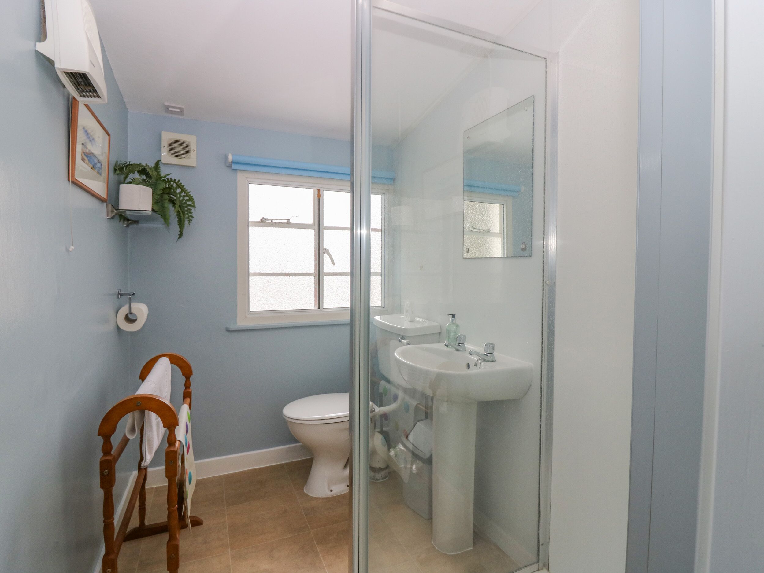 A bathroom with a toilet, sink, and shower area.