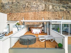 A modern spa area with a massage table, a hot tub, and a seating area with a table and chairs. - beautiful apartment with sea views Puerto Mogan (Mogán)