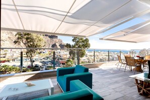 A rooftop terrace with a view of a cityscape and mountains. - Penthouse with great terrace and sea views (Mogán)