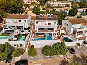 A multi-story residential building with a rooftop pool, balconies, and a landscaped garden.