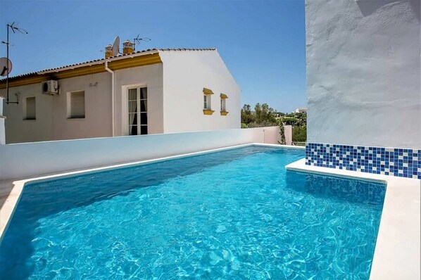 A swimming pool with a white building in the background.