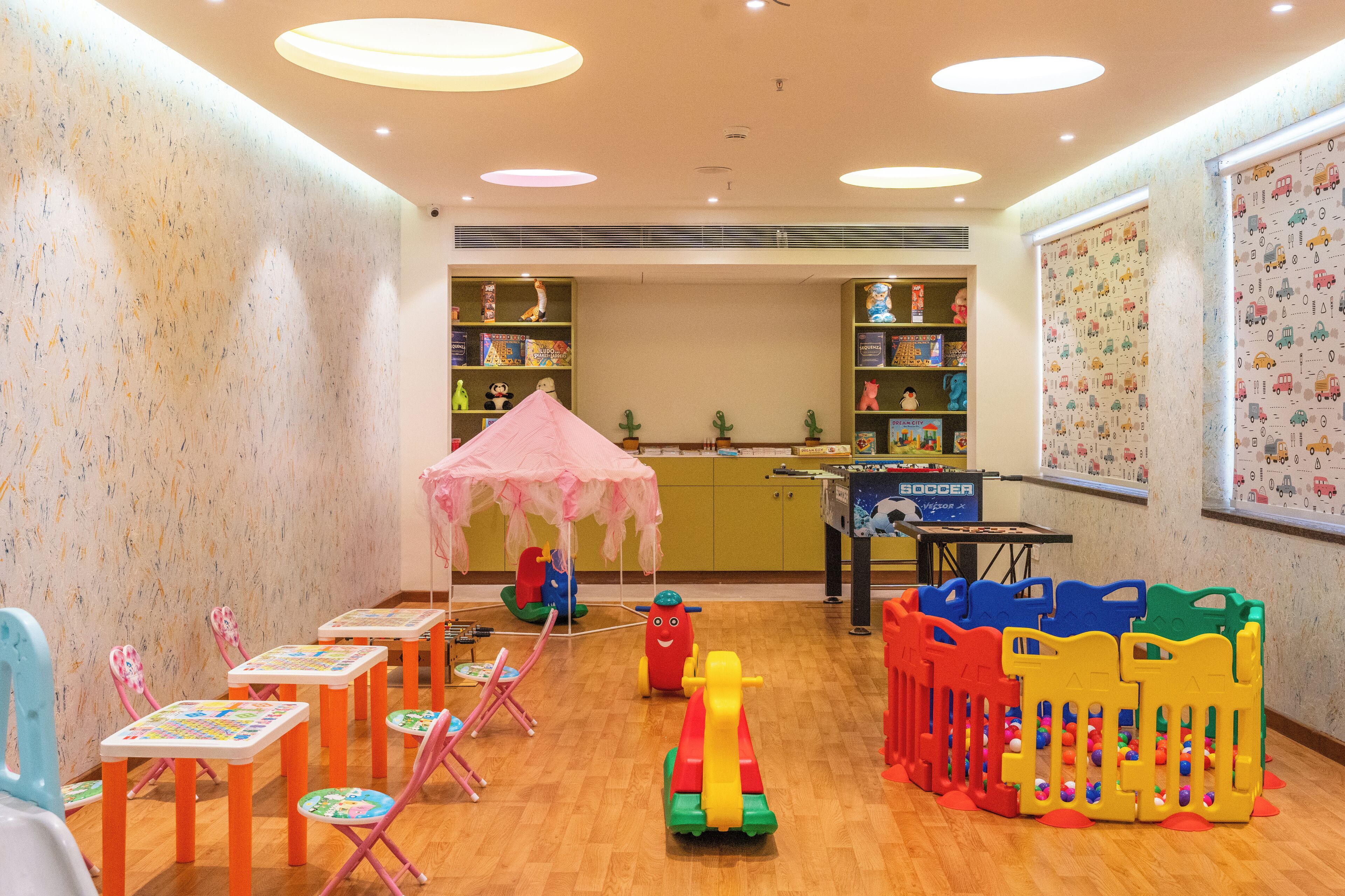 A children's play area with tables, chairs, and play structures.