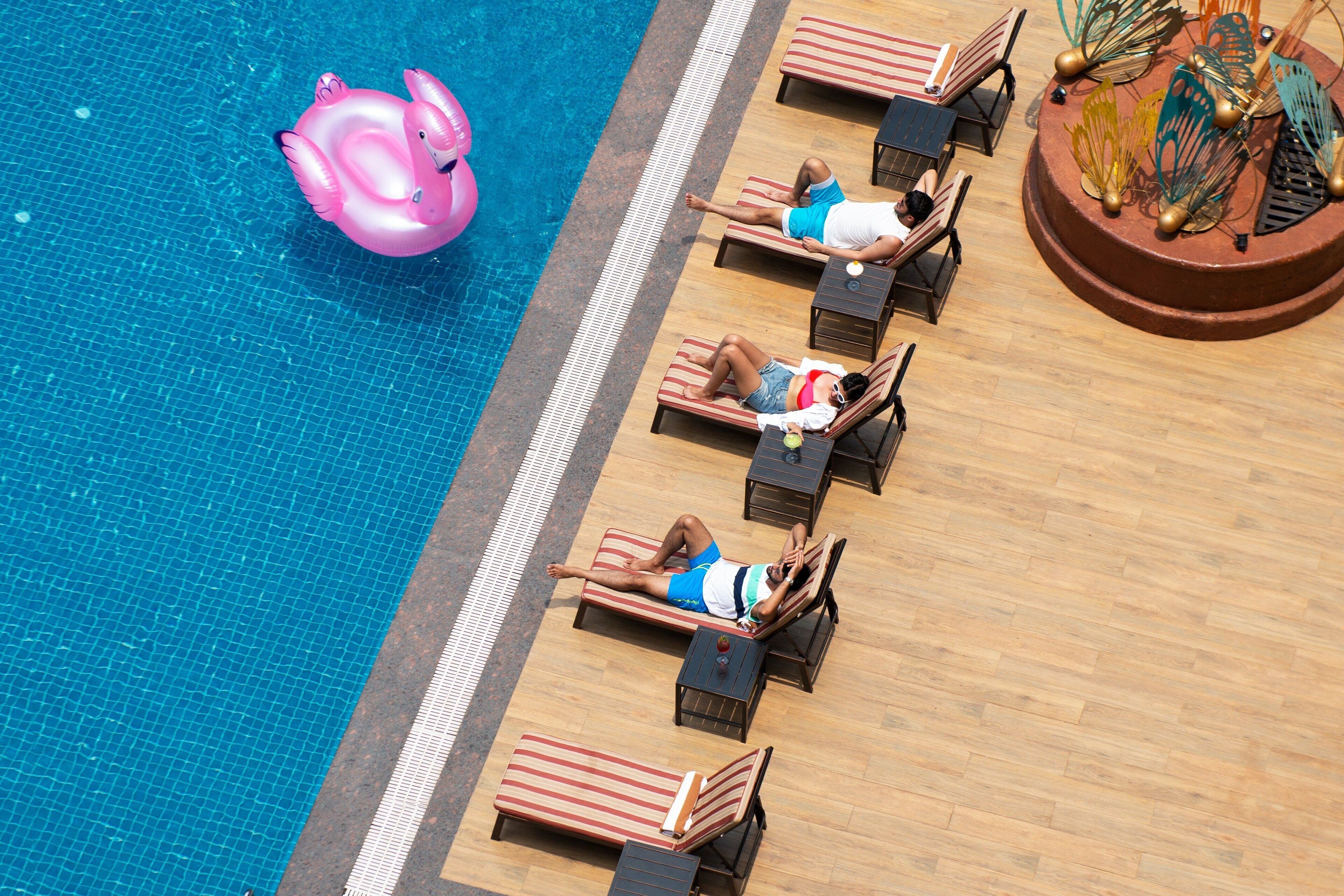 Ein Poolbereich mit Liegestühlen und einem Flamingo-Schwimmding.