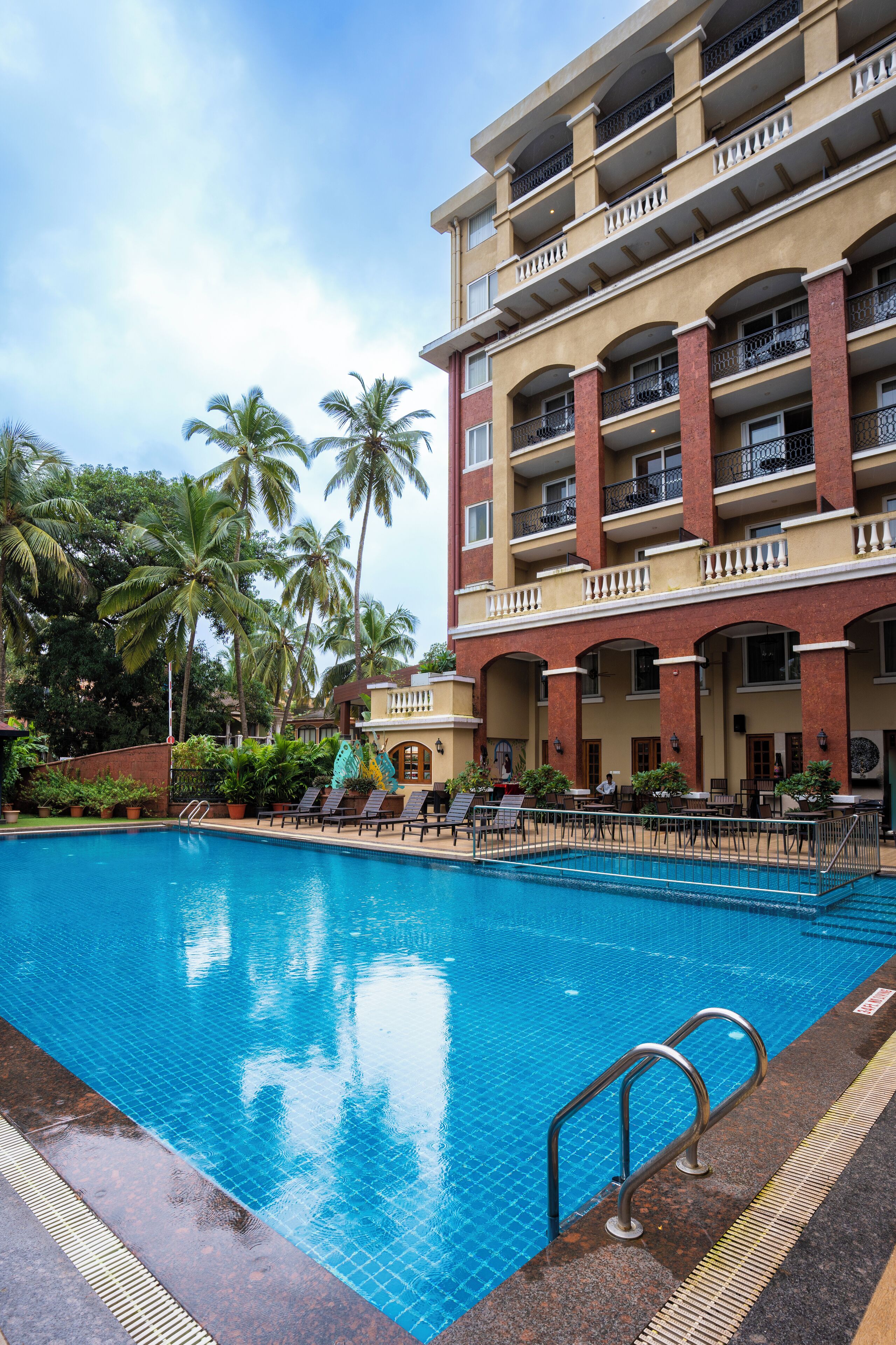 Een buitenzwembad, ligstoelen bij het zwembad