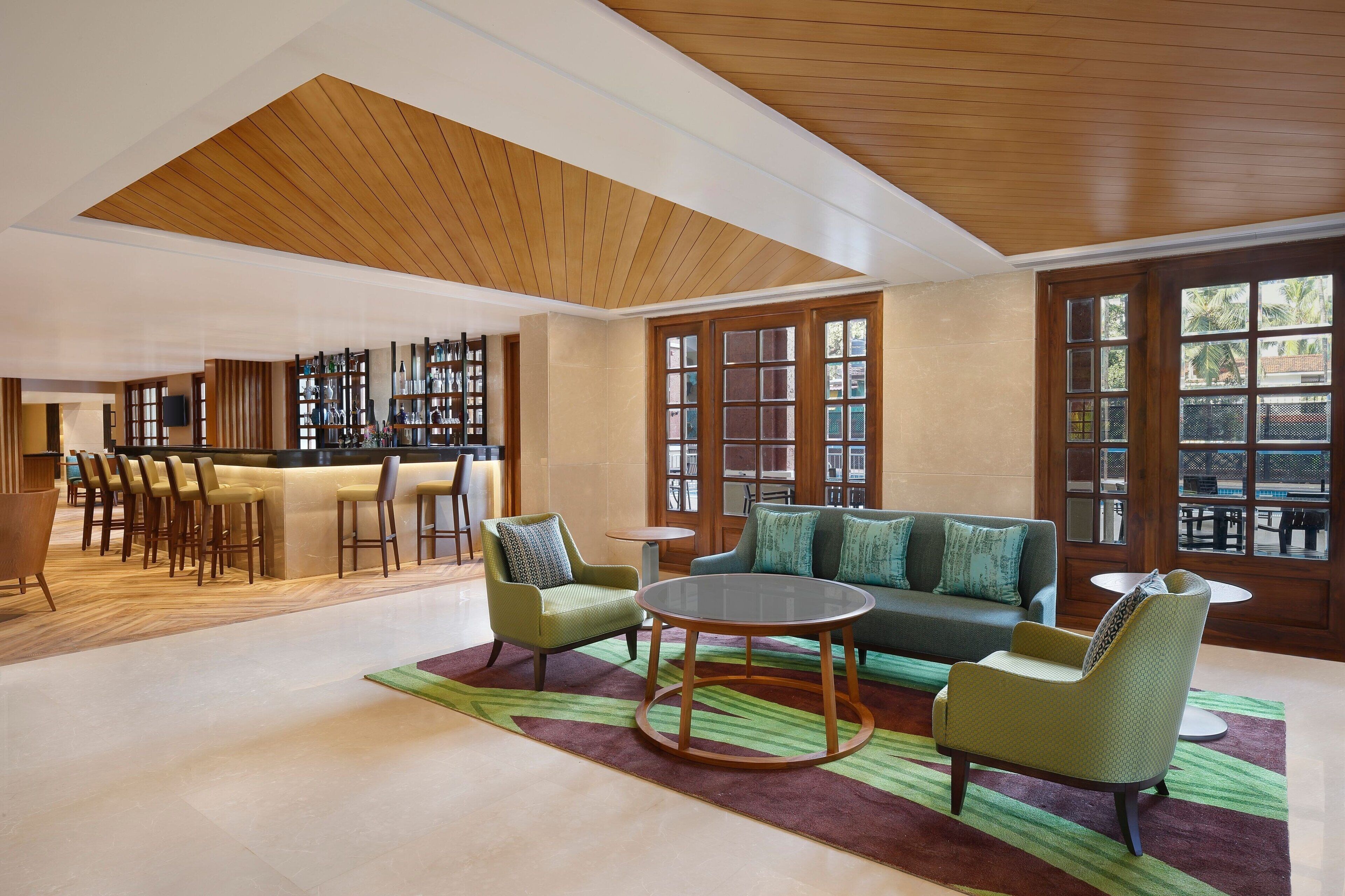 A spacious lobby with a bar area, seating arrangements, and large windows providing natural light.