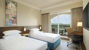 A hotel room with two beds, a desk, a chair, a TV, and a balcony with a view.