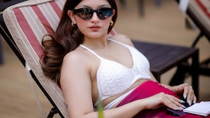 A person reclining on a striped lounge chair with a drink on the table. - Fairfield by Marriott Goa Calangute (Calangute)