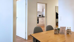 A dining area with a wooden table, chairs, and a sign reading "home2share welcome". - Schönes Apartment in Melle I home2share (Melle)
