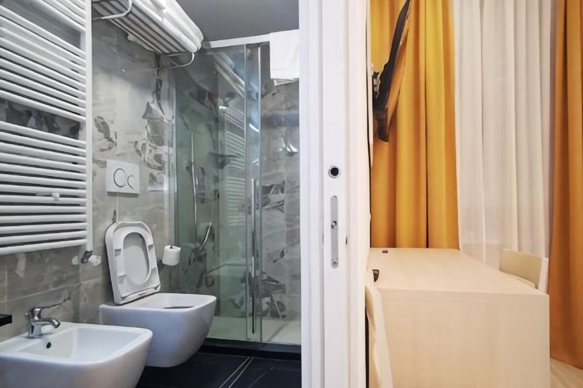 Une salle de bain avec une douche à parois de verre, deux lavabos et des toilettes.