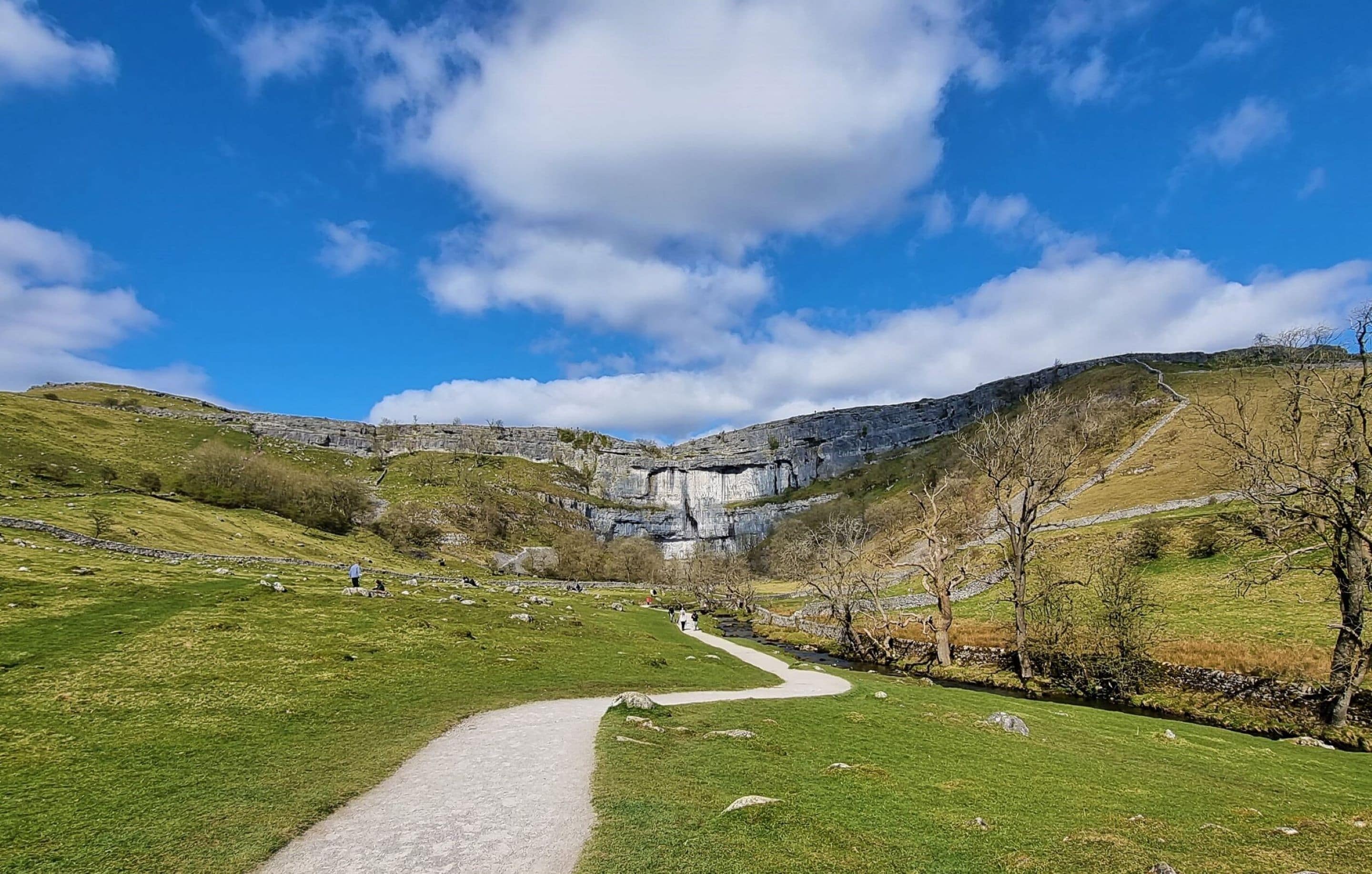 Ein Weg, der zu einer felsigen Klippe unter wolkenlosem Himmel führt.