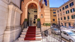 A hotel entrance with marble steps, a red carpet, and flags. - Hotel Ottaviano Augusto (Rome)