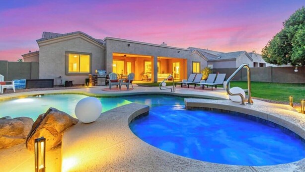 A modern house with a swimming pool, outdoor seating, and a well-lit patio area. - Dreaming Tree Retreat | Pool, Spa & Fire Pit (Phoenix)