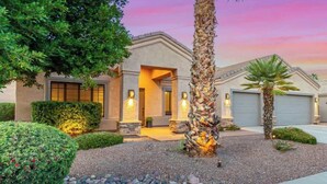 A modern house with a stone facade, a well-maintained garden, and a driveway leading to a garage. - Dreaming Tree Retreat | Pool, Spa & Fire Pit (Phoenix)