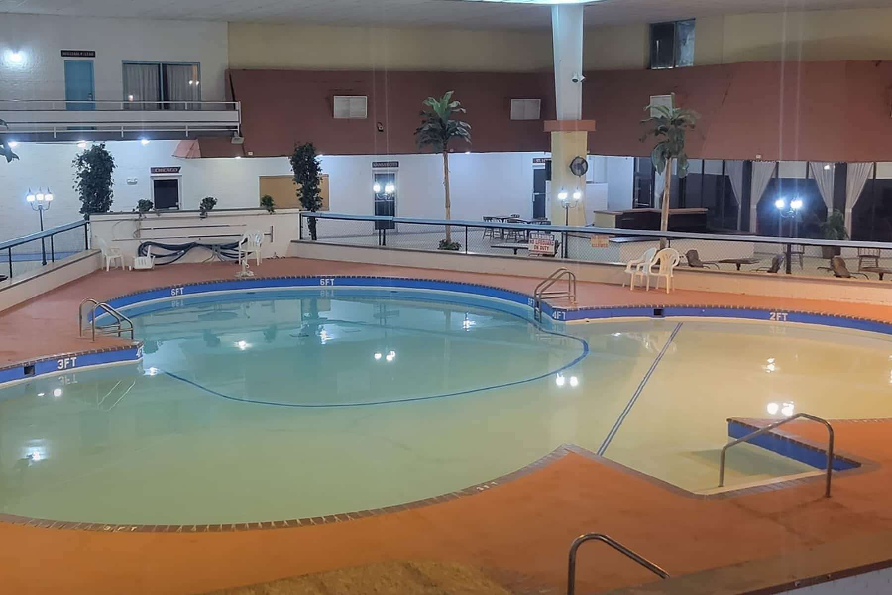 En inomhuspool med flera banor, ett område med solstolar och en solterrass med sittplatser.