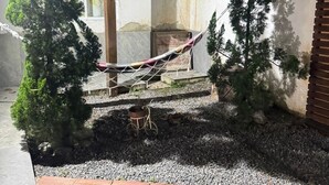 A hammock under a wooden pergola with potted plants and a star decoration. - Two minutes from the beach. House surrounded by nature. 500m² of private area. (São Sebastião)