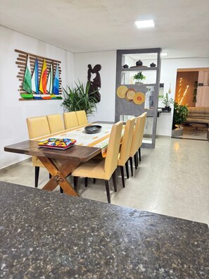 A dining area with a wooden table, yellow chairs, and a colorful table runner.