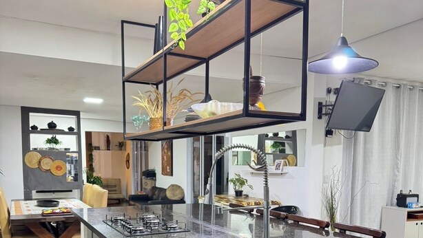 A modern kitchen with a central island, stainless steel appliances, and a hanging plant. - Two minutes from the beach. House surrounded by nature. 500m² of private area. (São Sebastião)