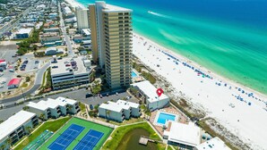 A coastal hotel with a tennis court, pool, and beach access.