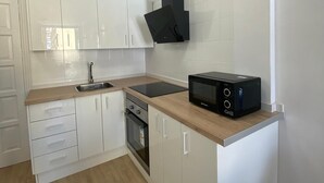 A compact kitchen with white cabinets, a black microwave, and a built-in oven. - Nice Apartment Playa Las Vistas. Free Wifi (Arona)