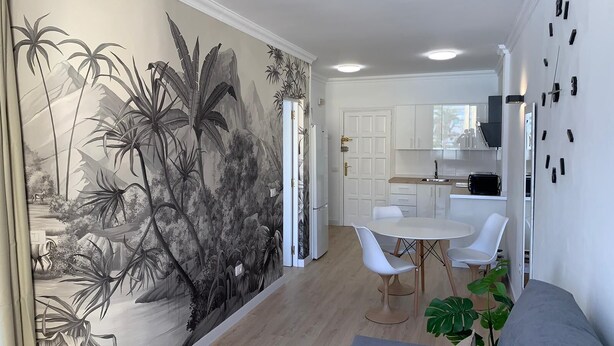 A modern living room with a mural, a dining area, and a kitchen. - Nice Apartment Playa Las Vistas. Free Wifi (Arona)