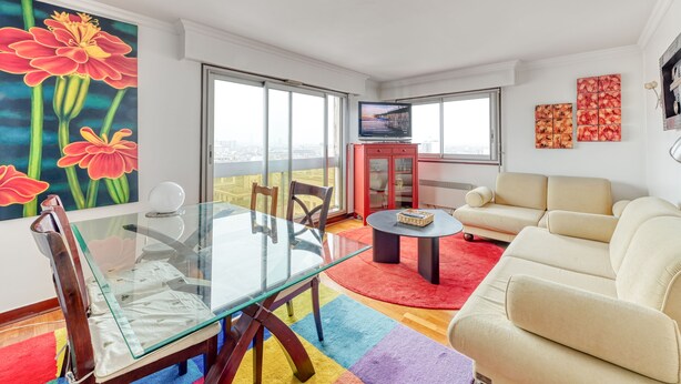 A modern living room with a glass dining table, beige sofa, and colorful rugs. - Panoramic view of Paris (Paris)