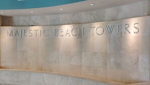 Ein Empfangsbereich mit dem Schild 'MAJESTIC BEACH TOWERS' an einer Marmorwand.
