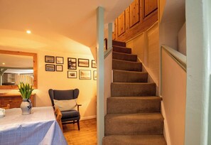 A staircase with carpeted steps leading to a landing with wooden cabinets.