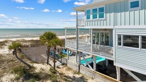 A beachfront property with a pool, outdoor seating, and a view of the ocean. - Island Life: Beachfront home, Sleeps 28, Pool, Pet-friendly, All the amenities! (St. George Island)