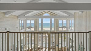 A spacious balcony with a view of the beach and ocean. - Island Life: Beachfront home, Sleeps 28, Pool, Pet-friendly, All the amenities! (St. George Island)