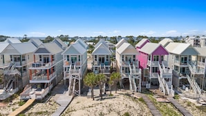 A beachfront hotel with multiple-story buildings, balconies, and wooden walkways. - Above the Dune: 3 Bedroom, Beachfront, Sleeps 8 (St. George Island)