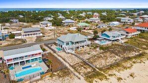 Zona residencial costera con casas, piscina y playa.