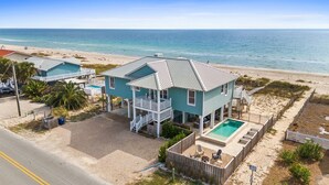Una casa costera con piscina, balcón y vistas a la playa.
