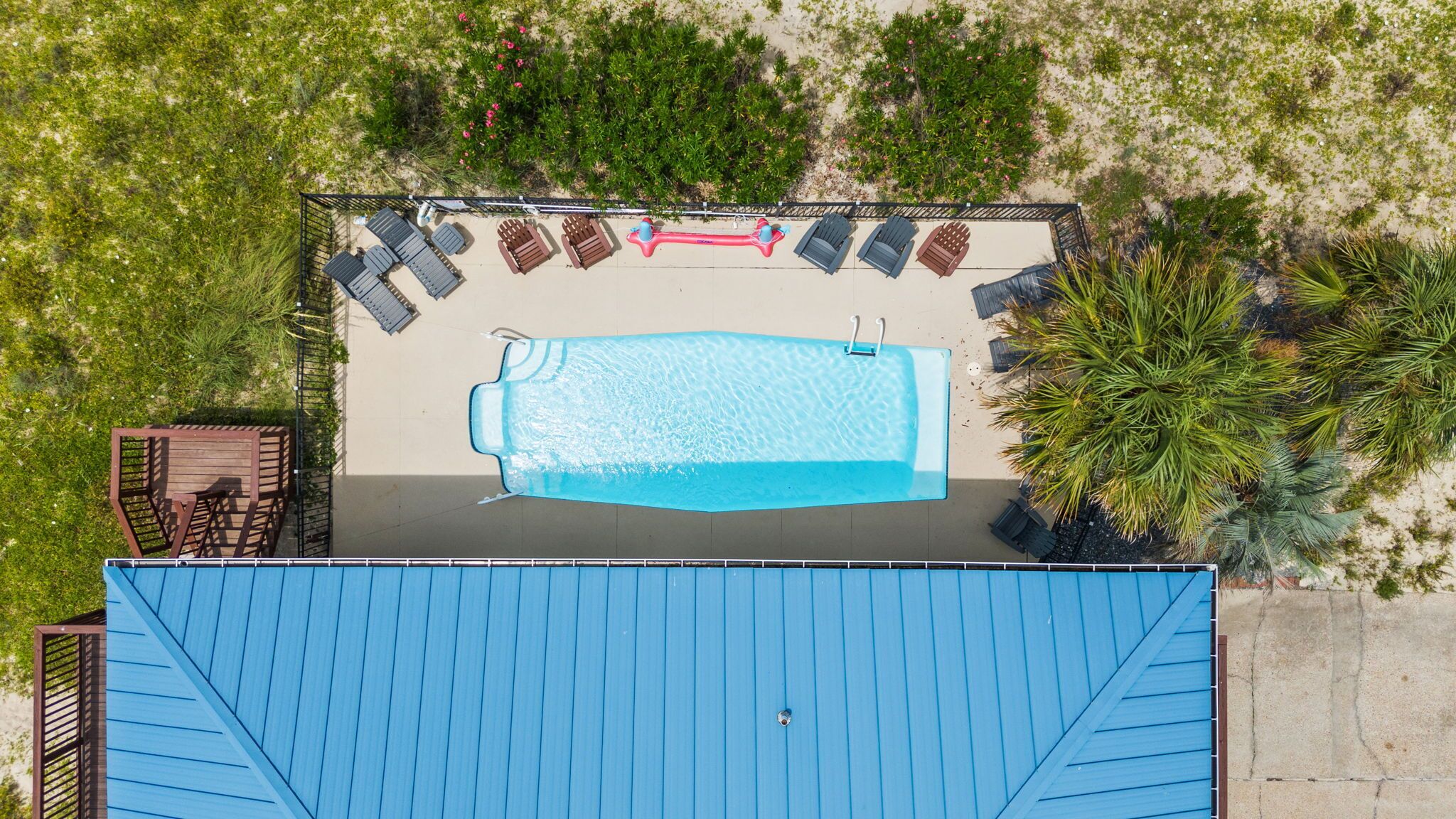 An aerial view of a swimming pool with lounge chairs and a deck area.