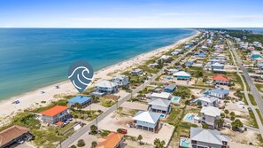 Une zone résidentielle côtière comprenant des maisons, une plage et une route.