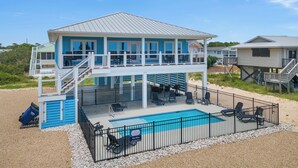 A two-story beach house with a pool, outdoor seating, and a covered patio. - Blue Skies: Gulf Views, Private Pool, Pet Friendly (St. George Island)