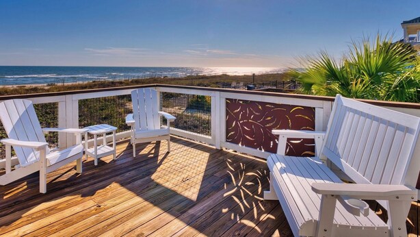 A wooden deck with white Adirondack chairs and a bench overlooking a beach. - Island Getaway: Beachfront home with amazing outdoor space & private pool! (St. George Island)