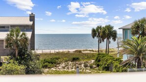 A beachfront property with a view of the ocean, a sandy beach, and palm trees. - On the Half Shell: Beach View, Private Pool, One level Home (St. George Island)